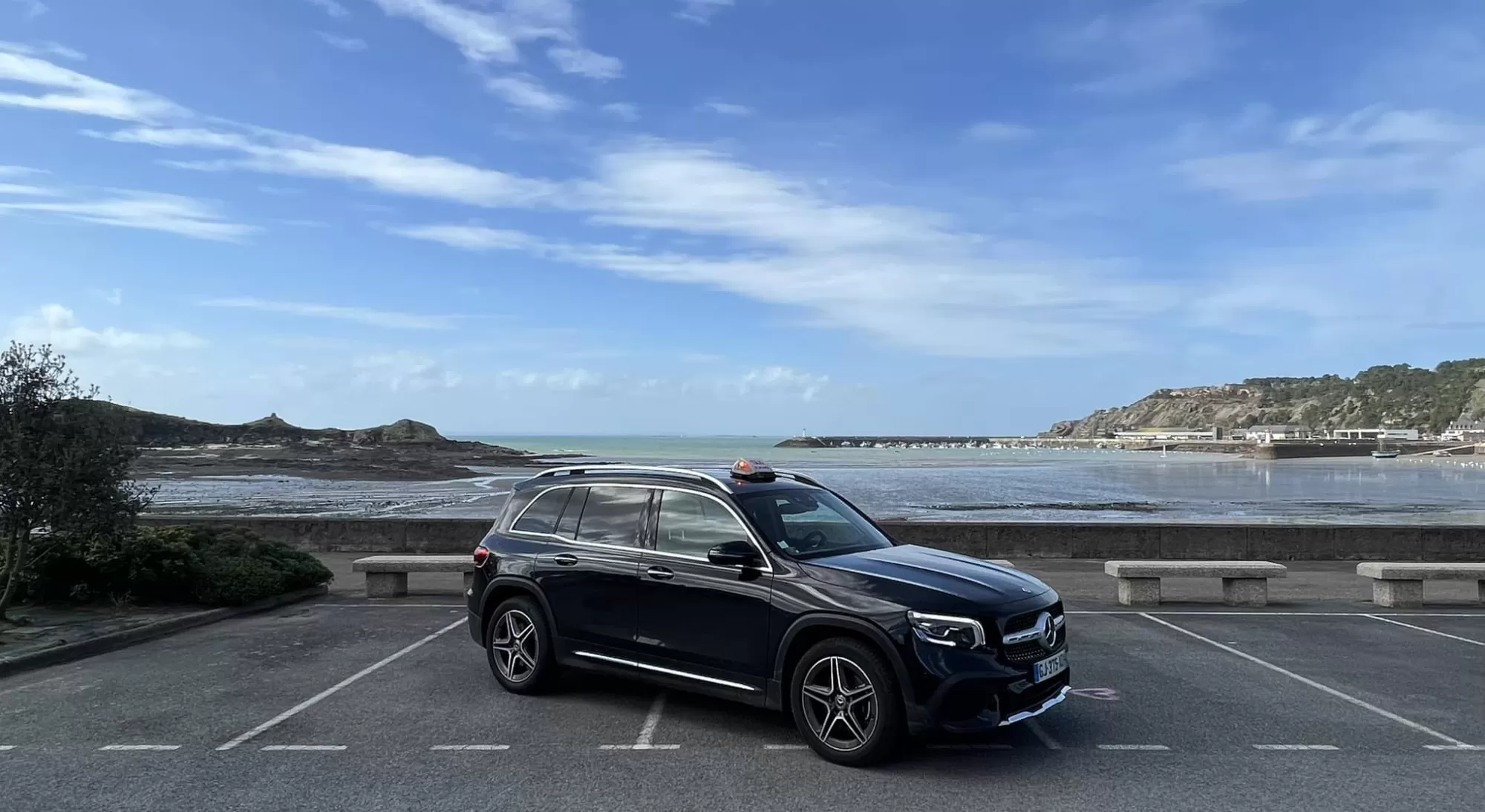 Taxi mercedes noir devant la mer sur la Côte d'Emeraude